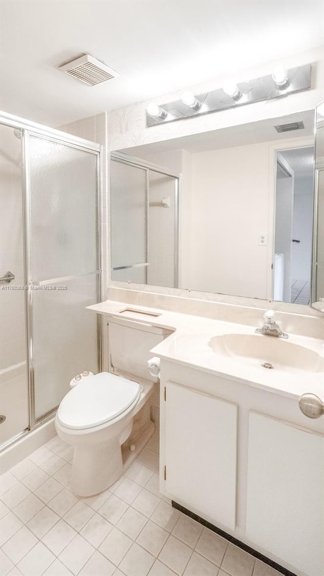 bathroom with tile patterned floors, visible vents, toilet, a stall shower, and vanity