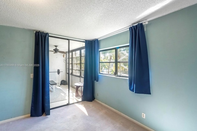 unfurnished room with baseboards, a textured ceiling, and carpet