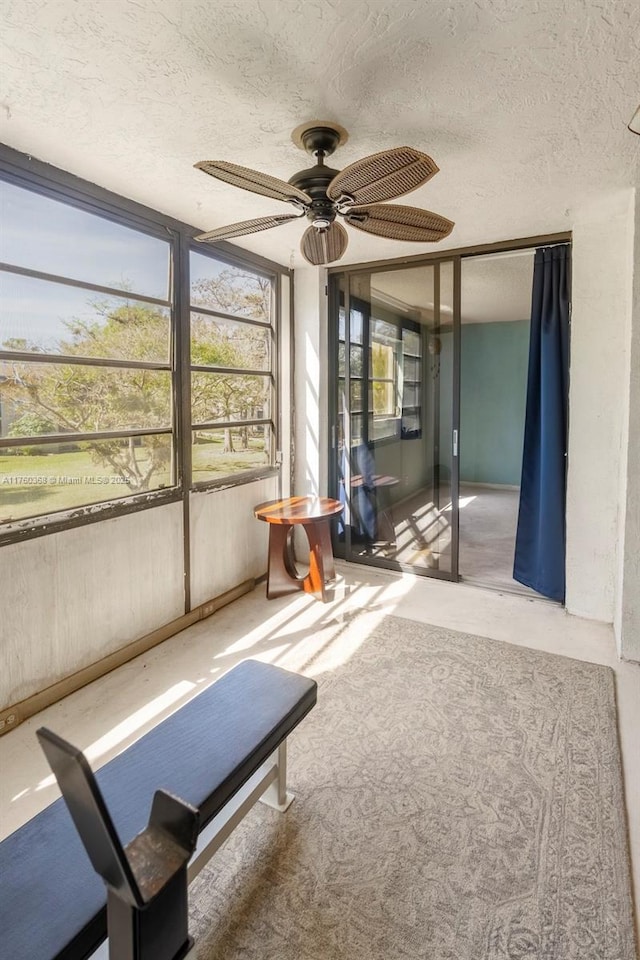 unfurnished sunroom with a ceiling fan