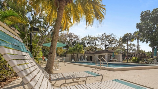 community pool with a patio and fence