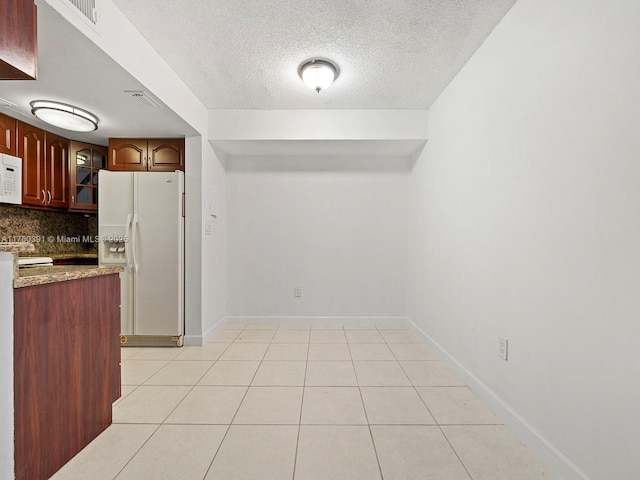 8585 NW 6th Ln Unit 9-208, Miami, FL 33126 - kitchen featuring white appliances, backsplash, glass insert cabinets, a textured ceiling, and light tile patterned floors