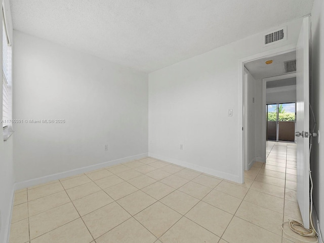 8585 NW 6th Ln Unit 9-208, Miami, FL 33126 - spare room with light tile patterned floors and a textured ceiling