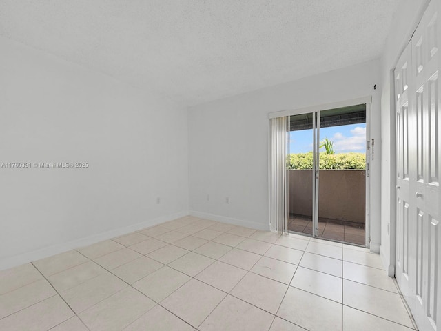 8585 NW 6th Ln Unit 9-208, Miami, FL 33126 - spare room featuring a textured ceiling and light tile patterned flooring