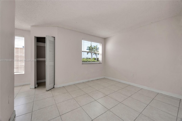 unfurnished bedroom featuring a closet, baseboards, and a textured ceiling