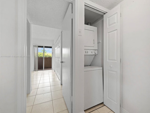 8585 NW 6th Ln Unit 9-208, Miami, FL 33126 - laundry room with stacked washer and clothes dryer, a textured ceiling, and light tile patterned floors