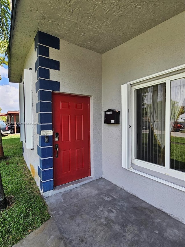 doorway to property featuring stucco siding