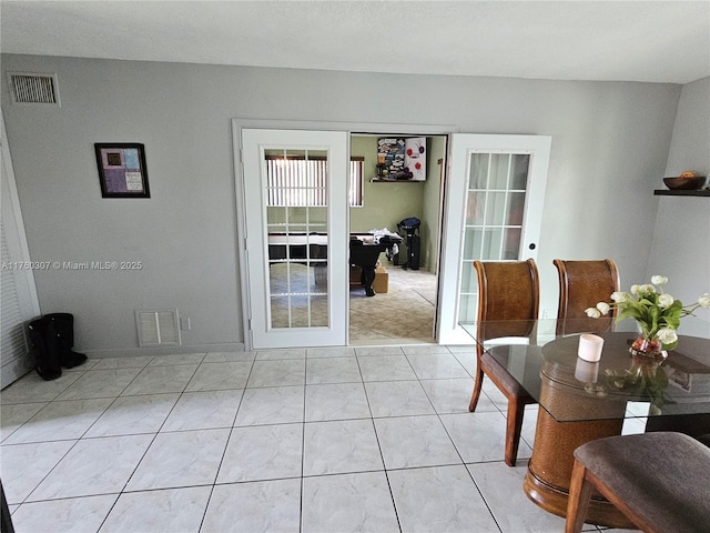 interior space featuring light tile patterned floors, french doors, and visible vents