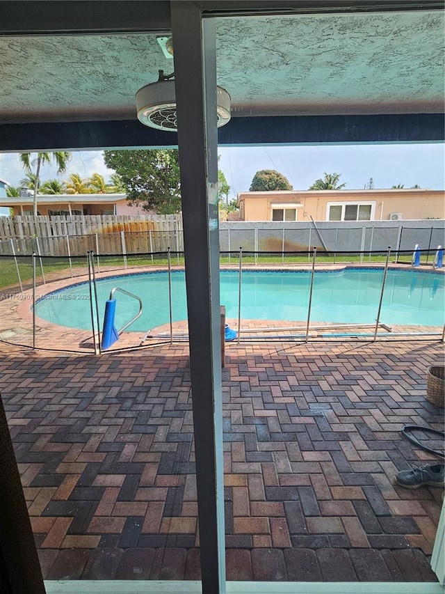 view of swimming pool featuring a lanai, a fenced in pool, a fenced backyard, and a patio area