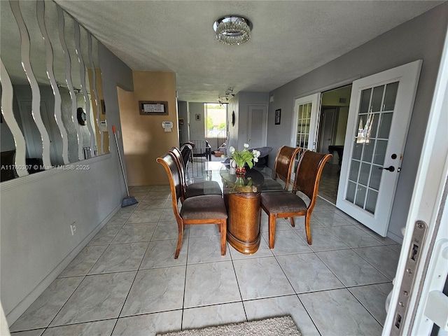 dining area featuring tile patterned floors and a textured ceiling