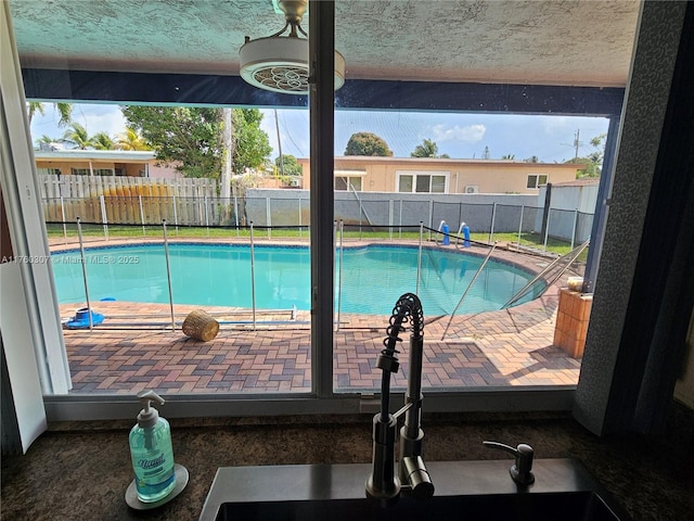 view of swimming pool featuring a sink, a fenced in pool, and a fenced backyard