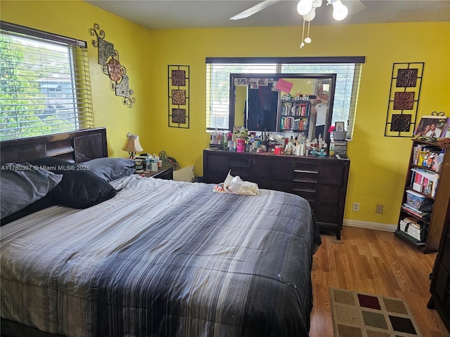 bedroom with ceiling fan, baseboards, and wood finished floors