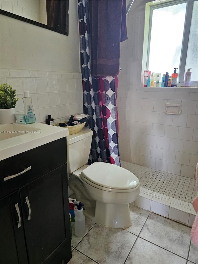 full bathroom featuring vanity, tile patterned flooring, a shower stall, tile walls, and toilet