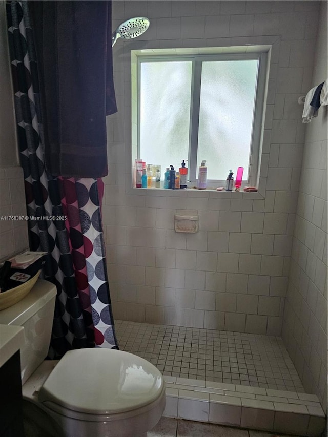 full bathroom featuring toilet and a tile shower