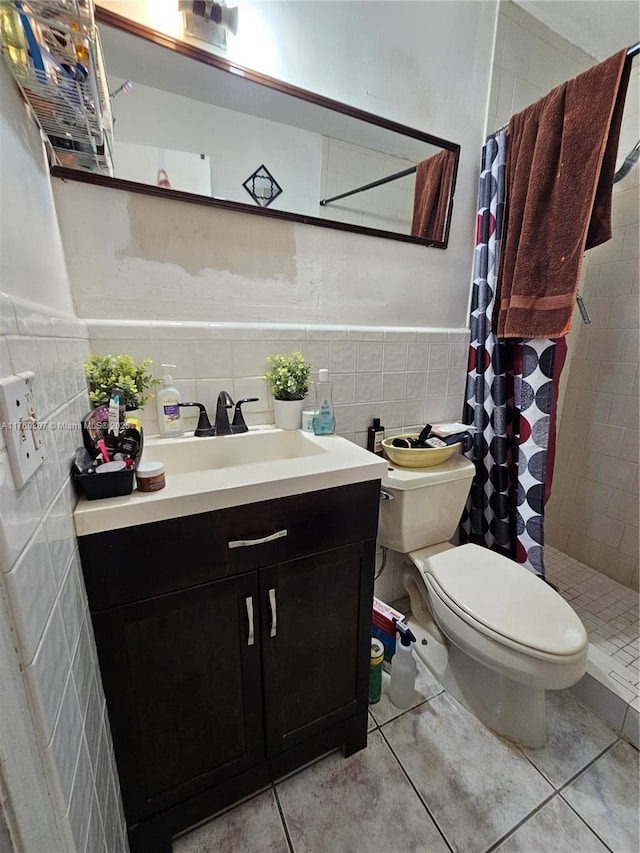 bathroom with vanity, tile walls, toilet, and a stall shower