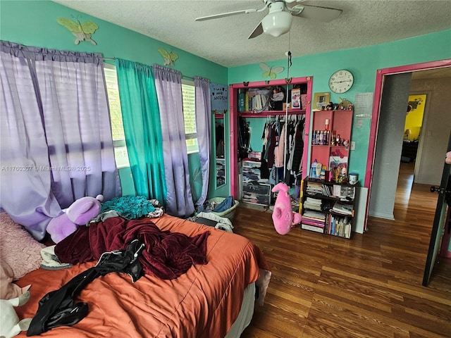 bedroom featuring a ceiling fan, wood finished floors, a closet, and a textured ceiling