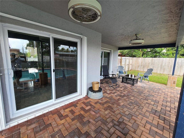 view of patio / terrace with a fire pit and fence