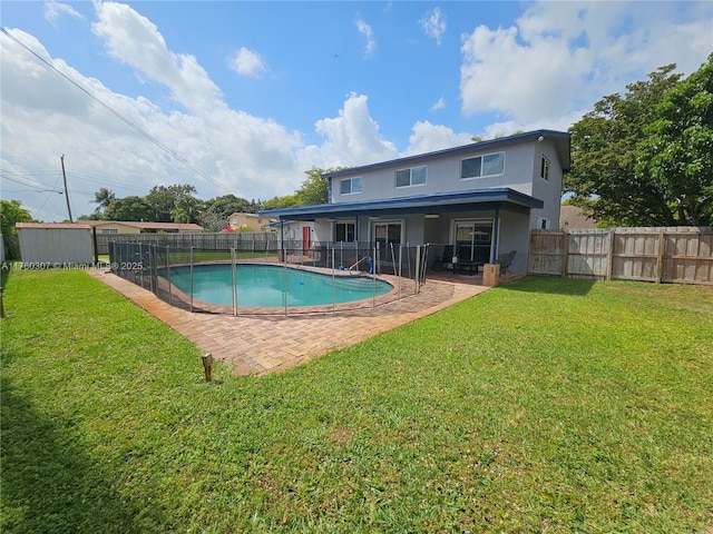 view of pool featuring a patio area, a lawn, and a fenced backyard