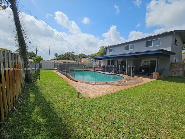 view of swimming pool featuring a patio, a lawn, a fenced in pool, and a fenced backyard