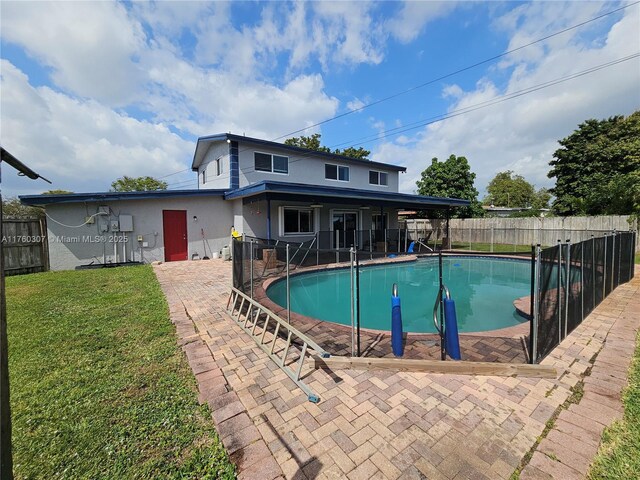 view of pool with a fenced in pool, a patio, a lawn, and a fenced backyard