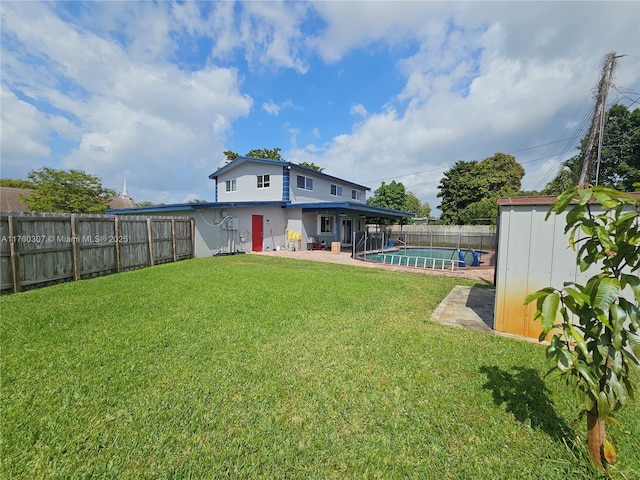 view of yard featuring a fenced in pool, a patio area, a fenced backyard, an outbuilding, and a storage unit