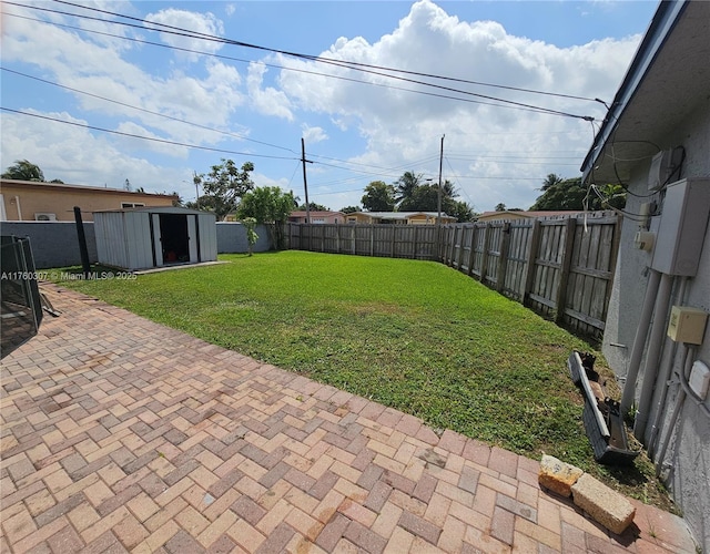 view of yard featuring a fenced backyard, a patio, a storage shed, and an outdoor structure