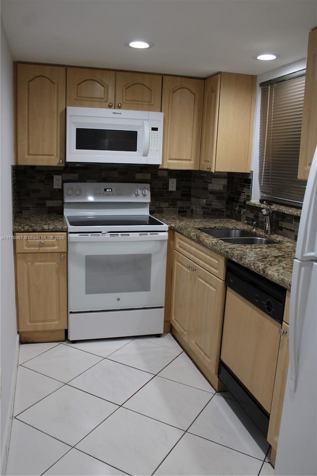 kitchen featuring light brown cabinets, a sink, tasteful backsplash, dark countertops, and white appliances
