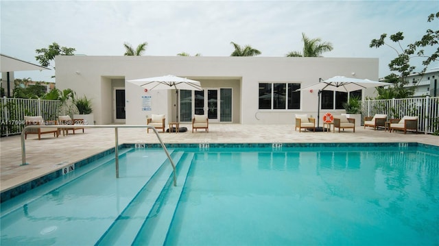 back of property featuring a patio area, a community pool, and fence