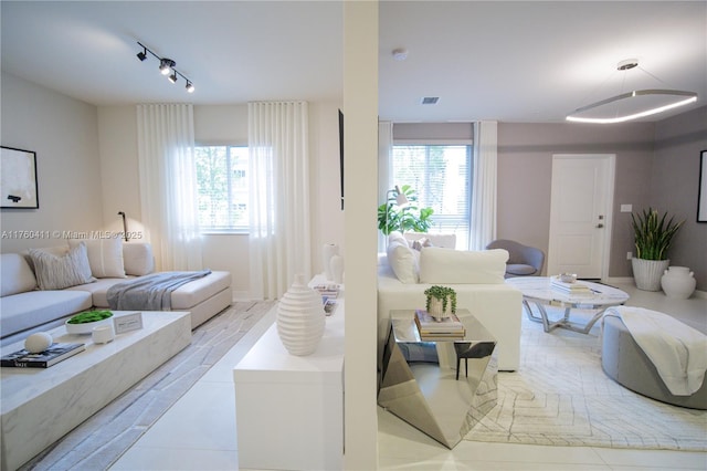 living room with rail lighting, plenty of natural light, and visible vents