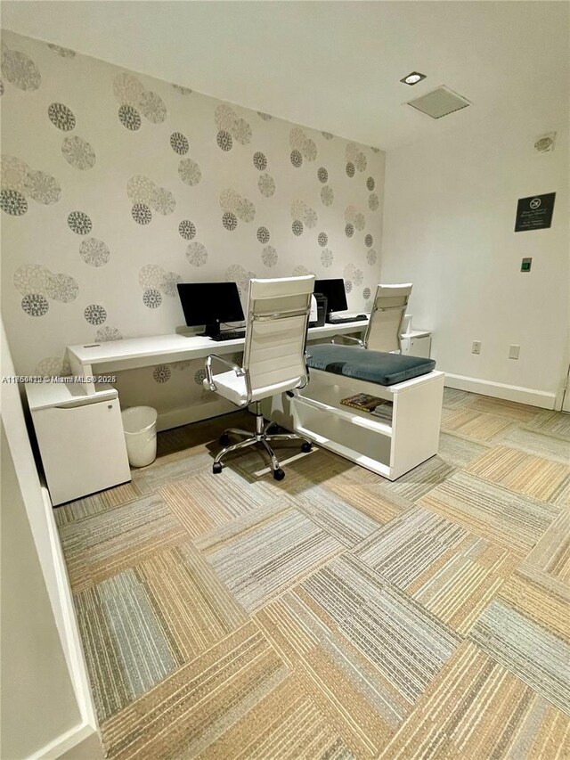 home office with wallpapered walls and baseboards