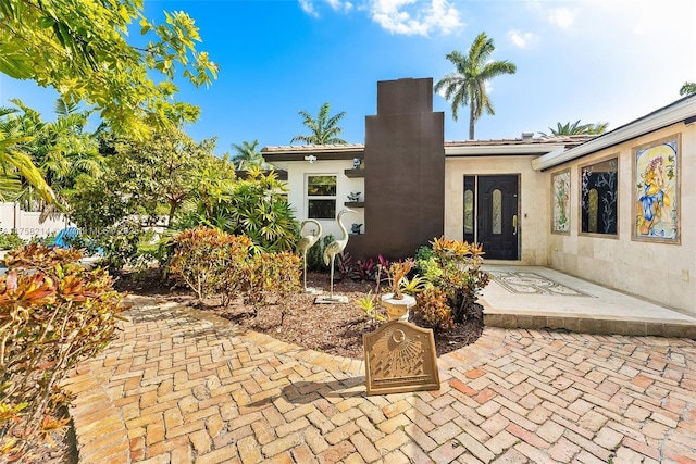 1134 Van Buren St, Hollywood, FL 33019 - rear view of house with stucco siding, a chimney, and a tile roof