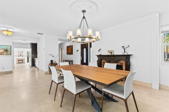 1134 Van Buren St, Hollywood, FL 33019 - dining area with baseboards, a warm lit fireplace, and a chandelier