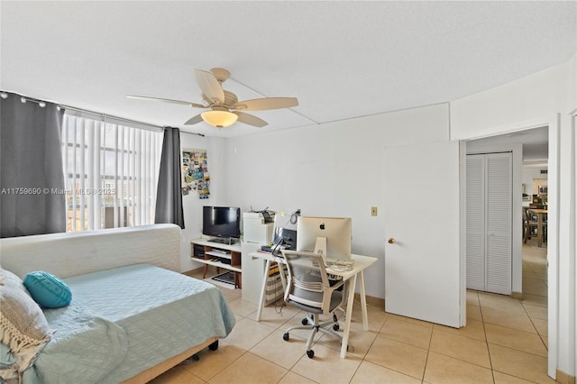 bedroom featuring ceiling fan, a textured ceiling, and light tile patterned flooring