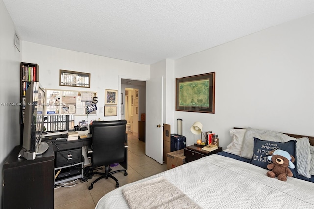 bedroom with a textured ceiling and tile patterned flooring