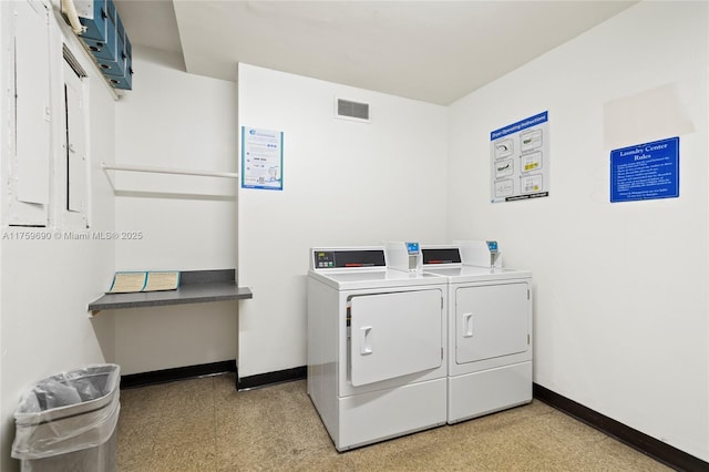 common laundry area featuring baseboards, visible vents, light floors, and washer and clothes dryer