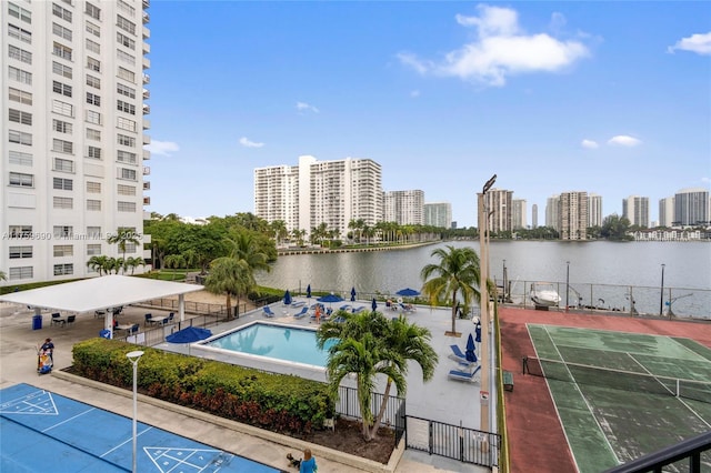 exterior space with a water view, shuffleboard, a city view, and fence