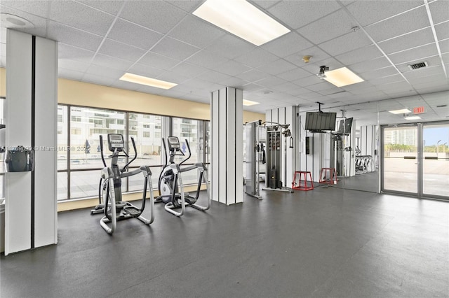 exercise room with a paneled ceiling and visible vents