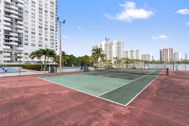 view of sport court with a view of city and fence