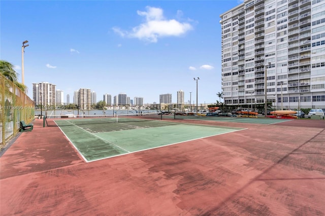 view of sport court with a city view and fence