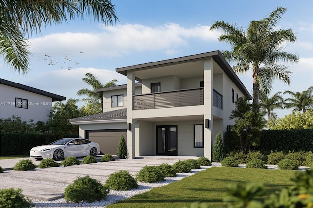 rear view of house with a balcony, a garage, driveway, and stucco siding