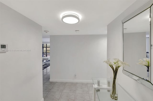 hall with light tile patterned floors and baseboards