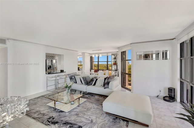 living area featuring light tile patterned floors and ornamental molding