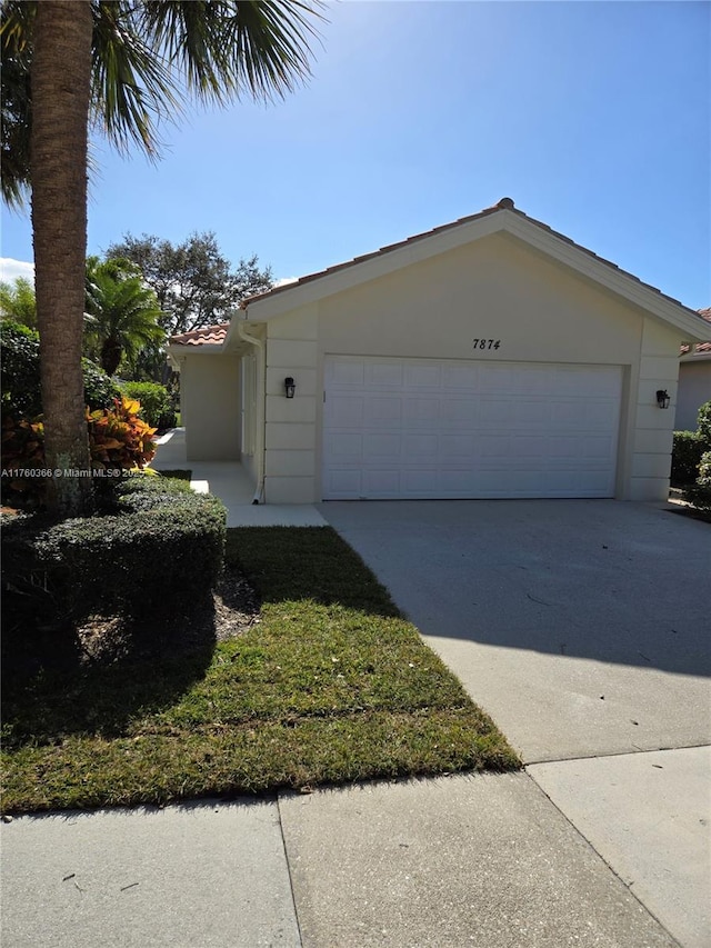 view of front facade featuring stucco siding, driveway, and a garage