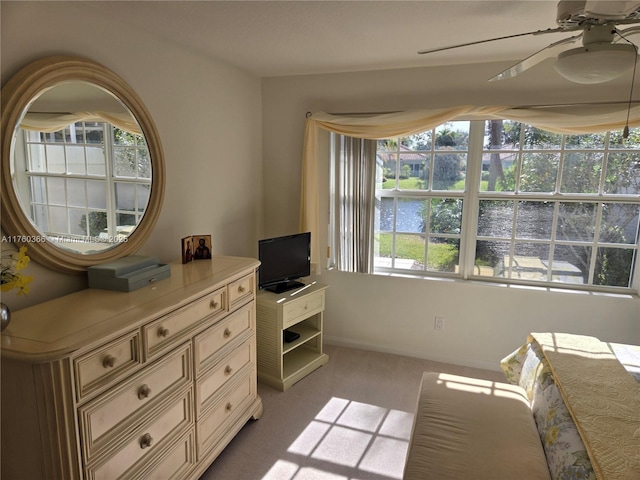 carpeted bedroom with multiple windows, a ceiling fan, and baseboards