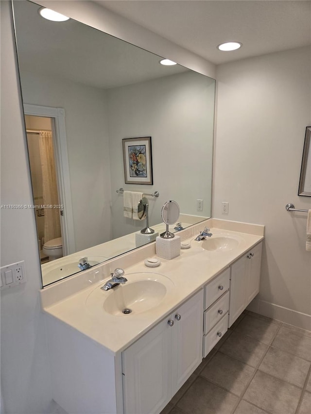 full bath with double vanity, tile patterned floors, and a sink