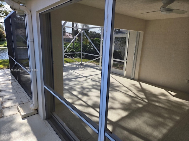 exterior space with concrete floors and a ceiling fan