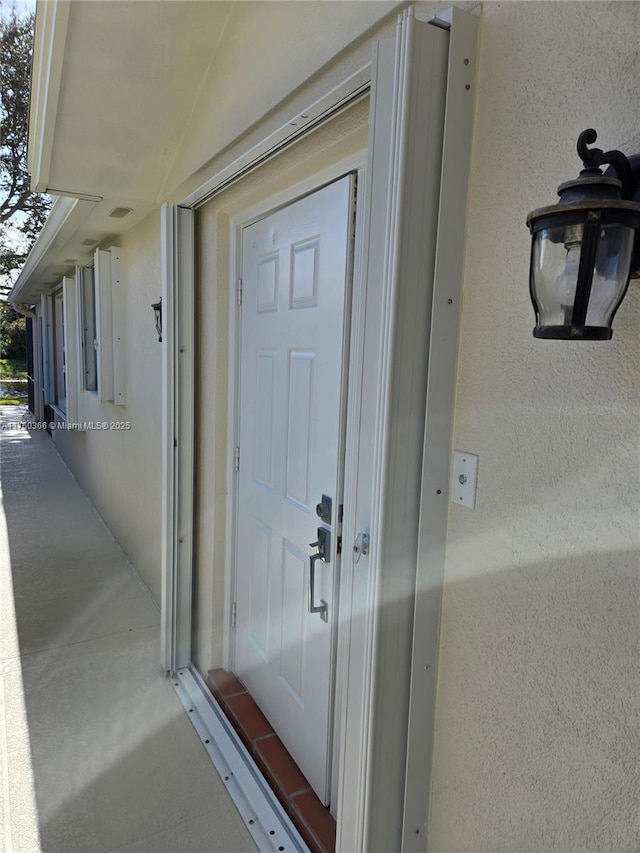 entrance to property featuring stucco siding