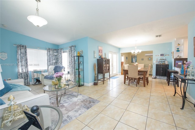 living room featuring light tile patterned floors, visible vents, plenty of natural light, and an inviting chandelier