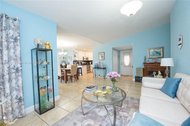 living area featuring light tile patterned flooring, a notable chandelier, baseboards, and lofted ceiling