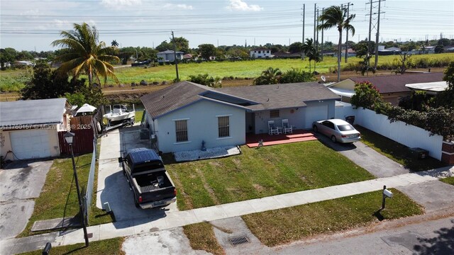 ranch-style home with stucco siding, a front lawn, driveway, and fence