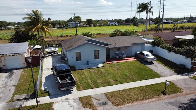 ranch-style home with a garage, aphalt driveway, fence, stucco siding, and a front lawn